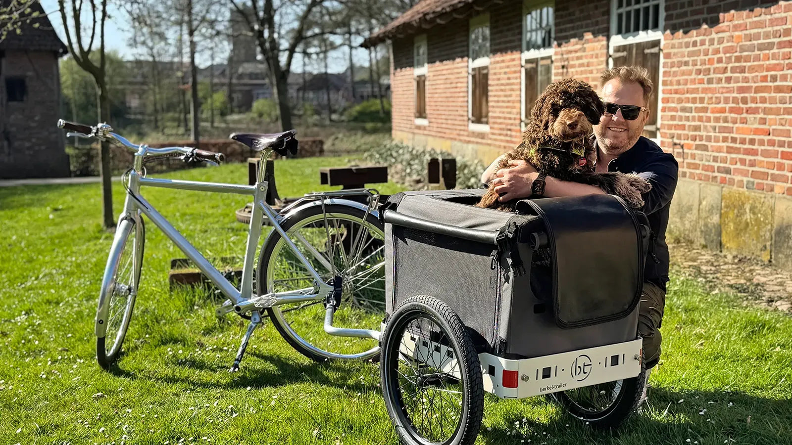 Hier ist Ralf mit seinem Hund Doke unterwegs. Eine Hundebox von Maelson auf einem Berkel-Trailer für eine komfortable Reise mit dem Fahrrad.