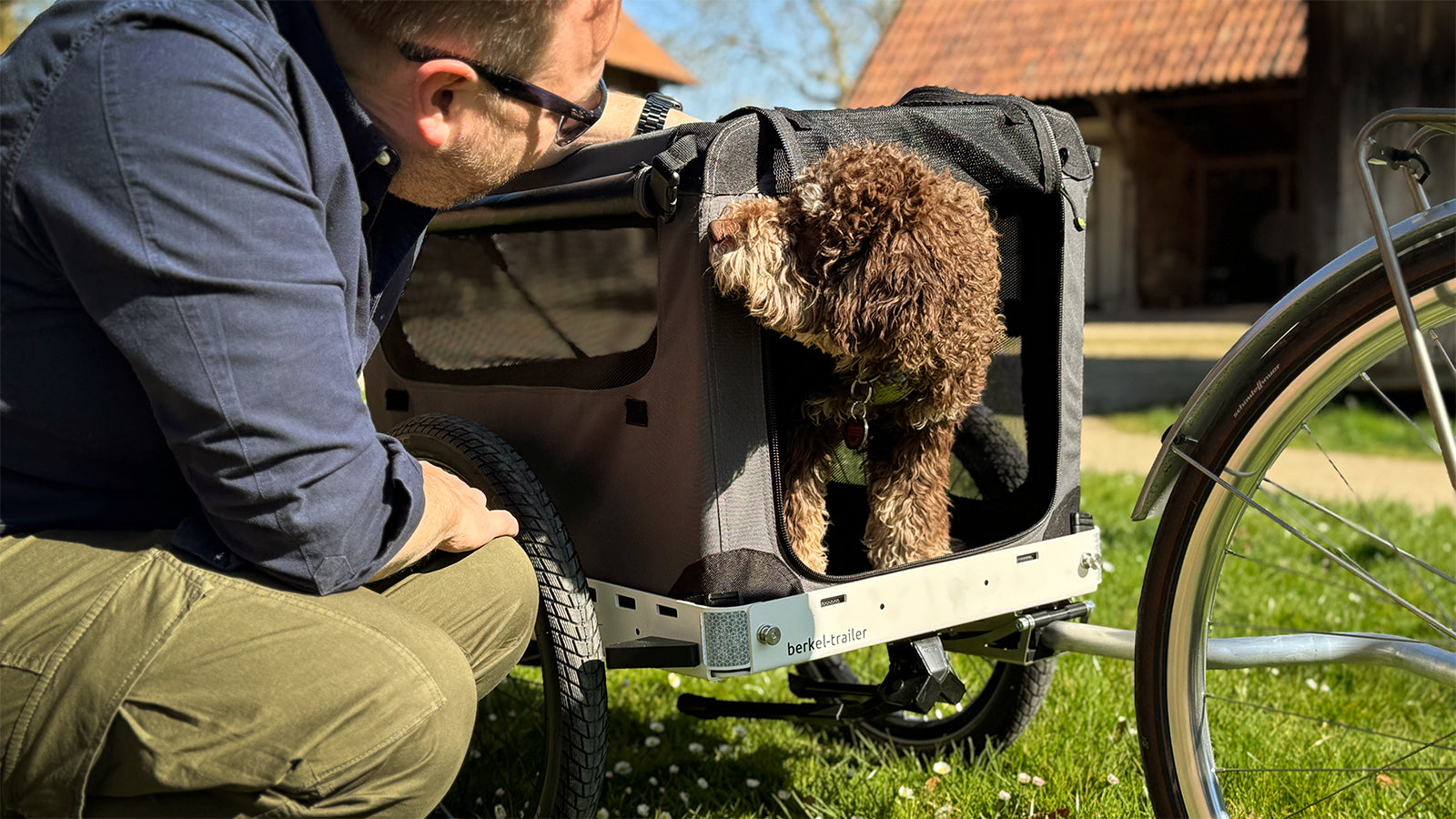Hier ist Ralf mit seinem Hund Doke unterwegs. Eine Hundebox von Maelson auf einem Berkel-Trailer für eine komfortable Reise mit dem Fahrrad.